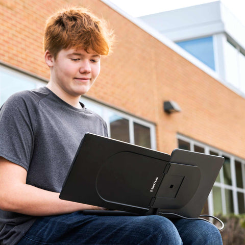 Étudiant apprenant en plein air avec son moniteur amovible.