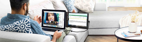 Man working from his couch while working from home on his SideTrak monitor for laptop