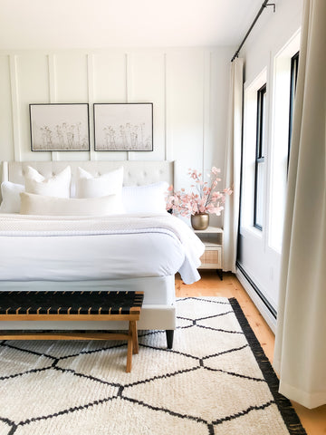 vilano white quilt on a white bed in a bedroom with a rug and big windows