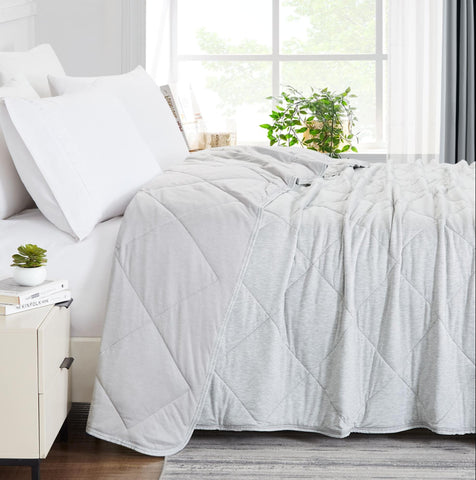 white cooling blanket on bed and white pillows