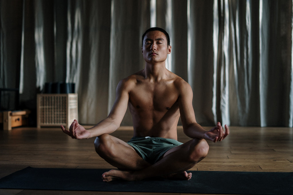 man sitting on a mat meditating