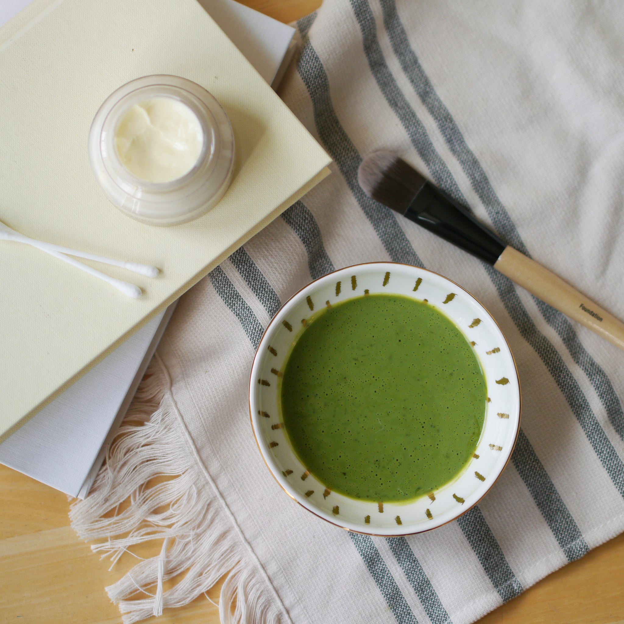 matcha face mask in a bowl and face cream