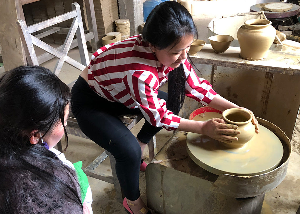 Sadhika makes a pot on the wheel