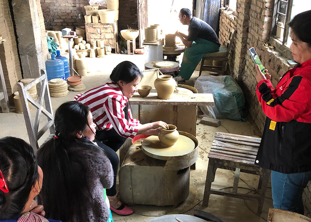 The team watch as each member gets a chance to throw a pot.