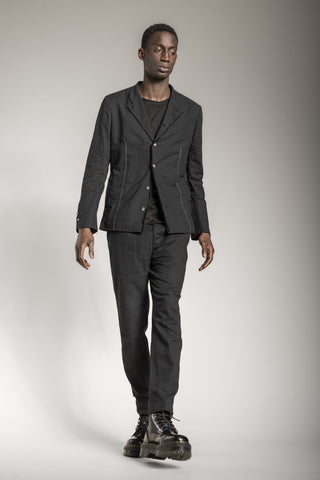 A man wearing an all black designer suit from eigensinnig wien