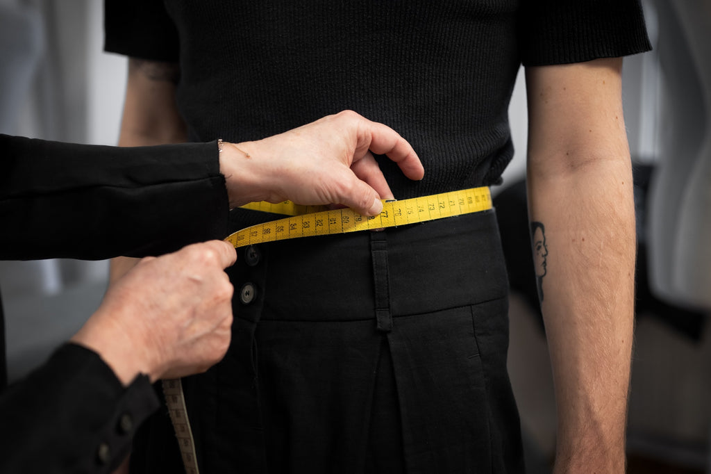 A woman taking measurements for a custom-made product