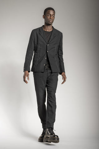 Ein Mann, der einen All Black Designer Anzug von eigensinnig wien trägt