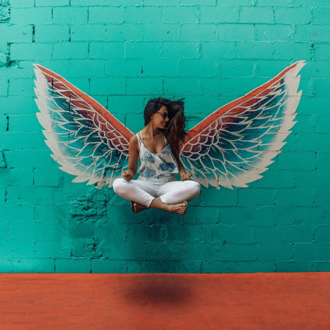 Girl in Easy Pose, floating in front of Angel Wings.