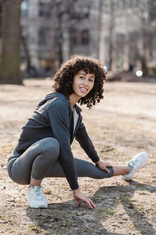 curly brown hair, woman stretching