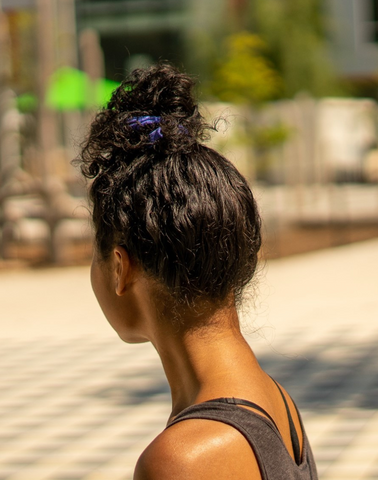 messy bun for curly hair with lilac scrunchie