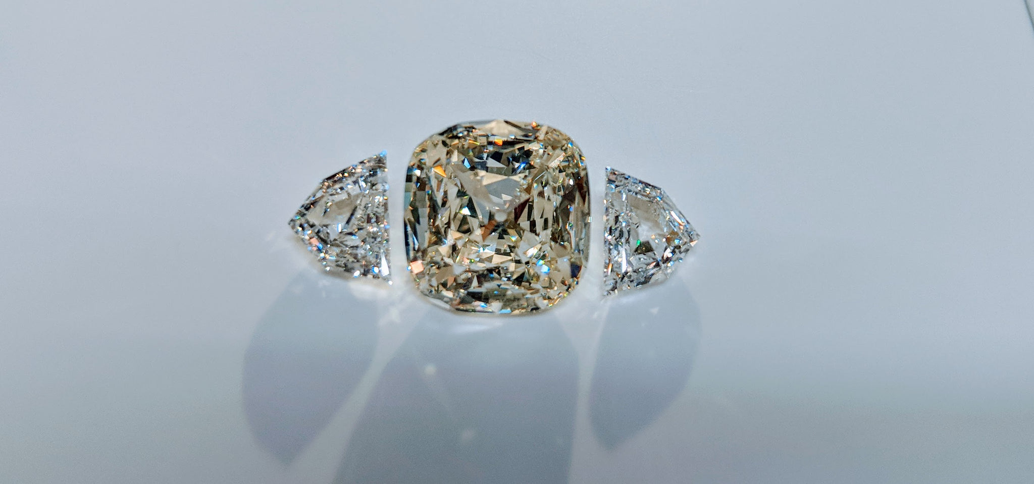 64Facets Diamond Setting with Two Half Shield Step-Cut Diamonds as Side Stones