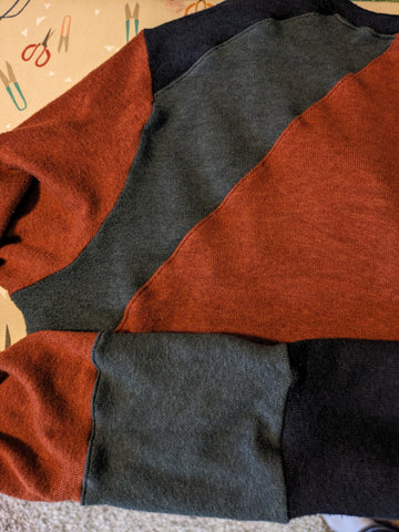The front and sleeve of a sweater, with topstitched wavy seams.
