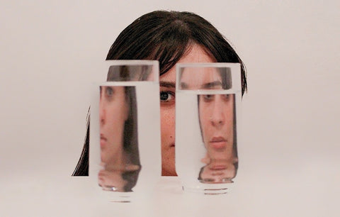 Rosto de mulher atrás de dois copos d'água