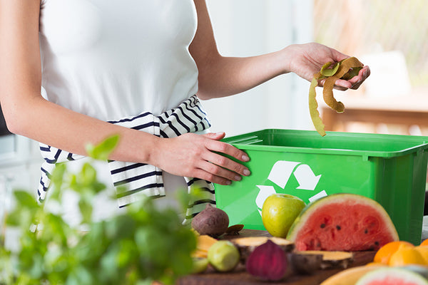 Mulher colocando cascas de fruta em lixo orgânico