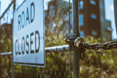 image of a fence with a sign that says road closed