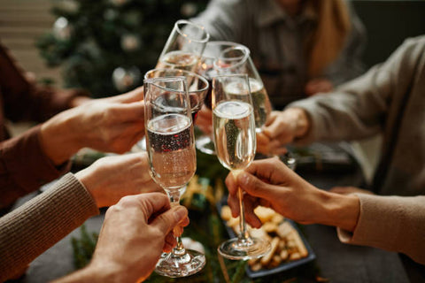 Image of hands holding champagne glasses and cheering to a toast