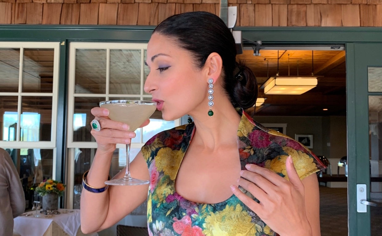 Aysha drinking a cocktail at a company event