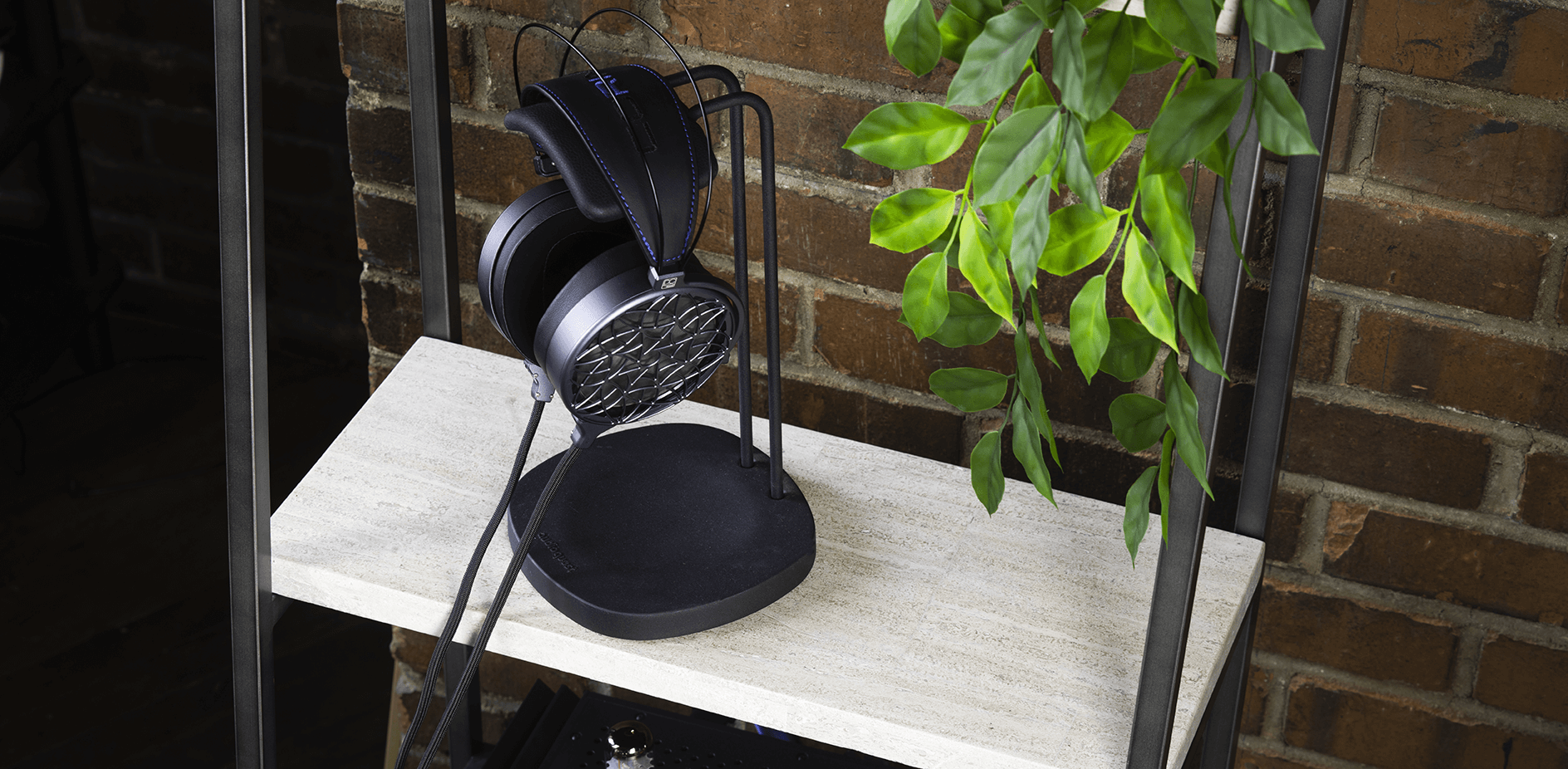 Photograph of Dan Clark Audio Corina on a headphone stand placed on a table.