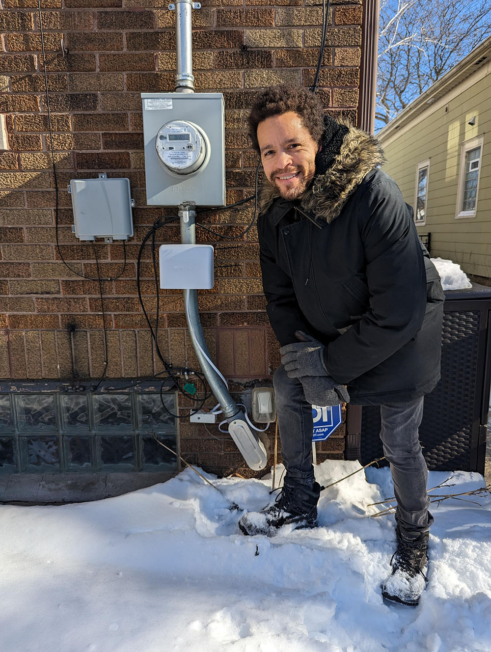Langston Verdin and an IQAir Outdoor air quality monitor in Riverwest