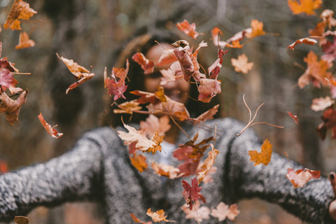 Woman throwing leaves in air