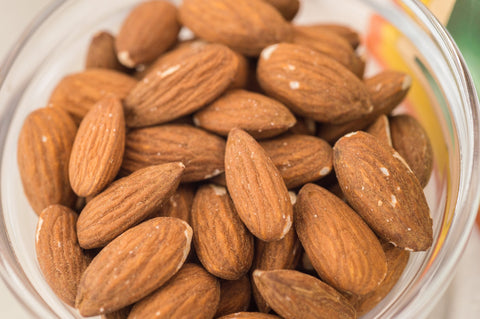 It is a square photo, with a bowl full of almonds