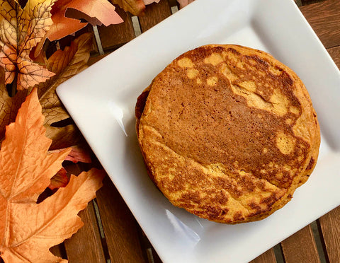 Protein rich and healthy gluten free dairy free almond flour pumpkin pancakes by piccola cucina stacked on white plate with autumn leaves