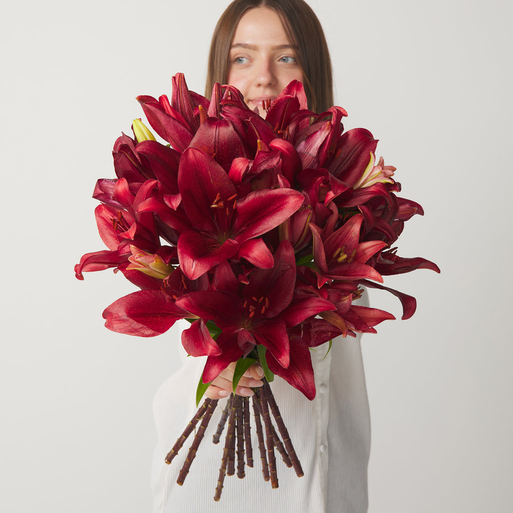 woman holding red lilies