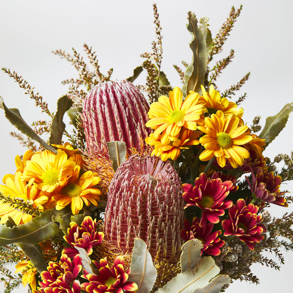 banksia in a bouquet of yellow and red blooms