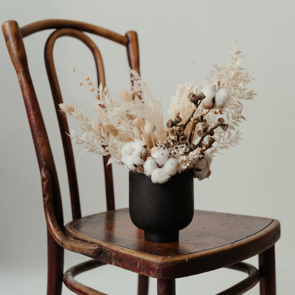 dried flowers in an opaque black ceramic vase