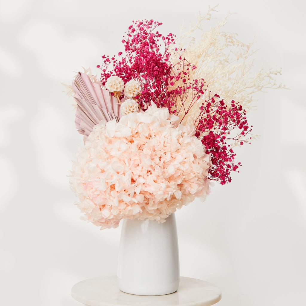 the serena dried flower bouquet, pink dried flowers in a white ceramic vase