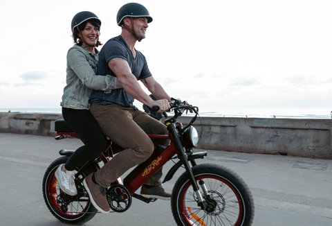 A group of happy e-bike commuters cycling together, highlighting the health and fitness benefits of integrating electric bikes into daily urban commutes.