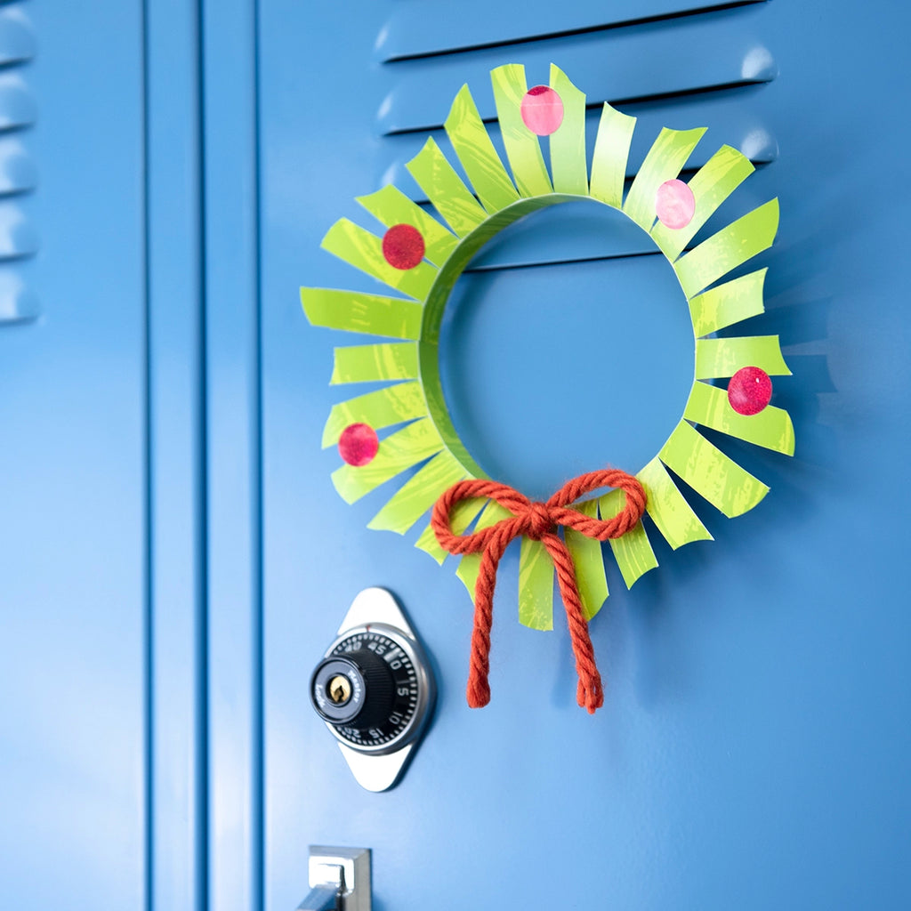 Classic holiday wreath made from paper trimmers and string hanging on a blue locker.