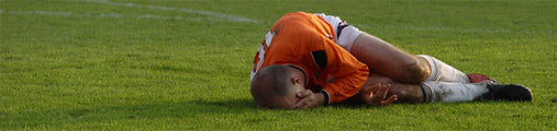 A football player lays on the field after a sports injury