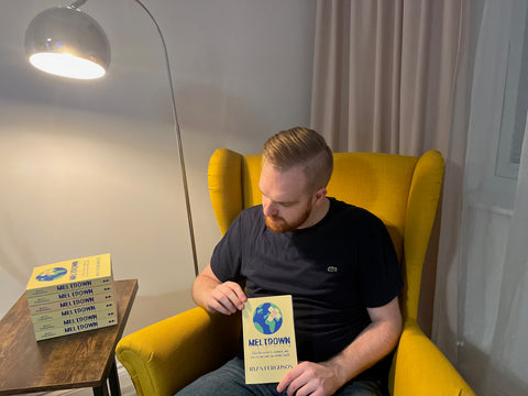 Writer Ryan Ferguson holding a copy of Meltdown, his third book