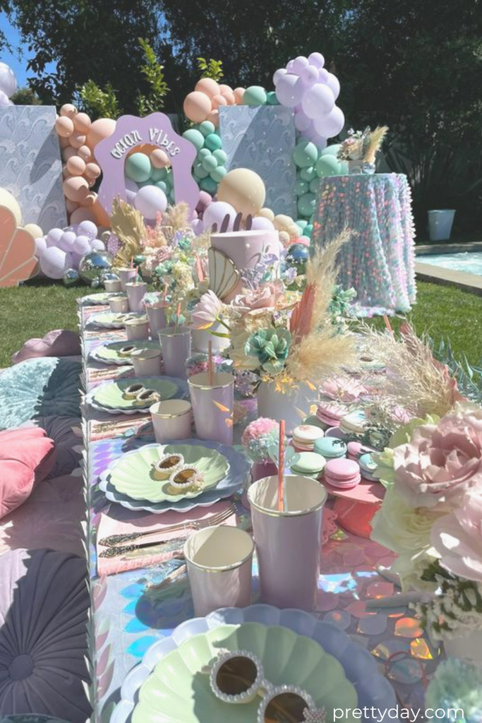 Meri Meri party supplies, a beautiful mermaid themed table setting with dried flowers and pastel balloons.