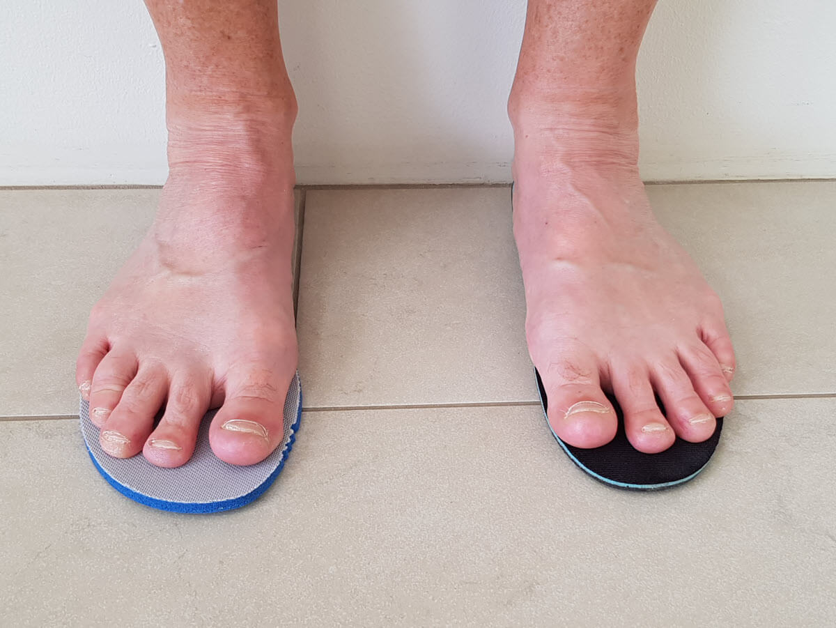 Performing the Toe Fit Check by standing on two different shoe insoles