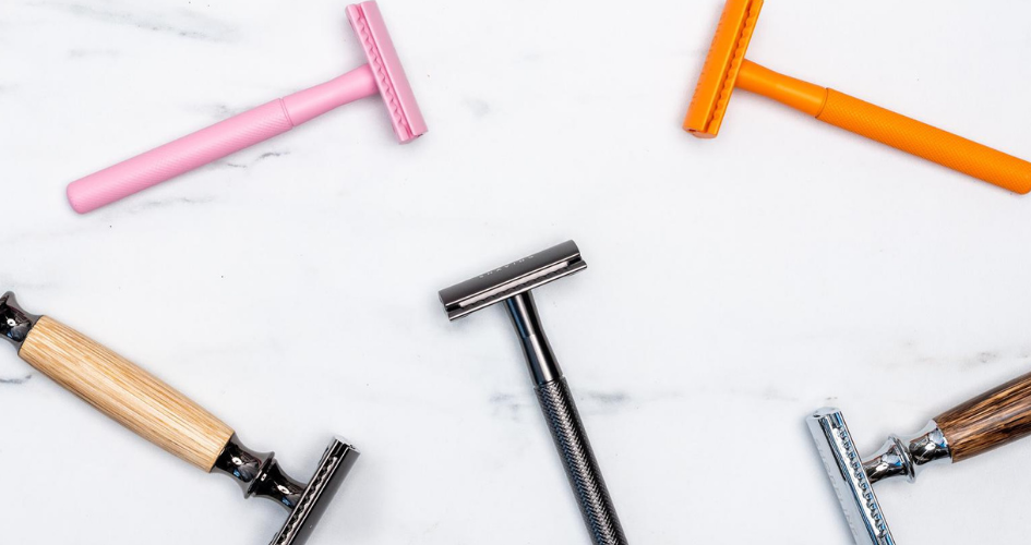 Different coloured safety razors including pink, orange, black and bamboo