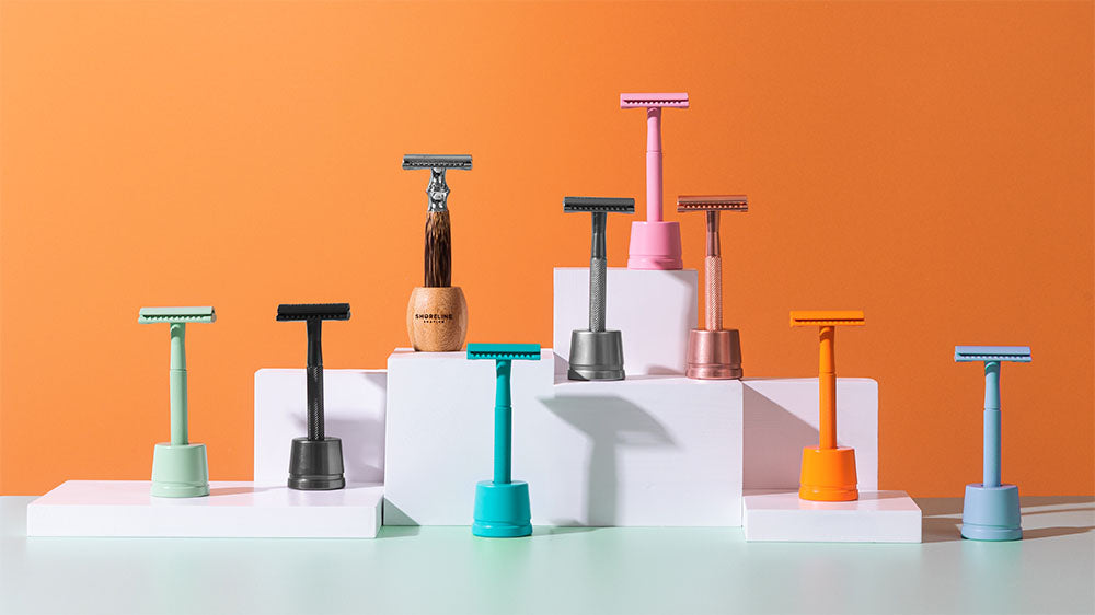 Range of multi-coloured safety razors in shaving stands - Shoreline Shaving