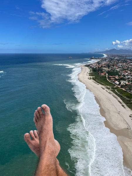 flying with feet above beach below