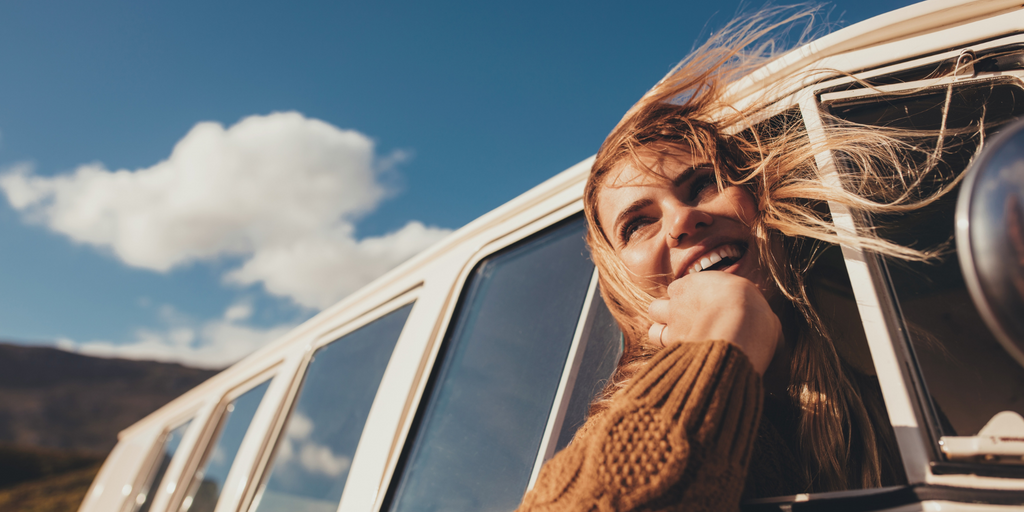 Girl sticking head out of the car window