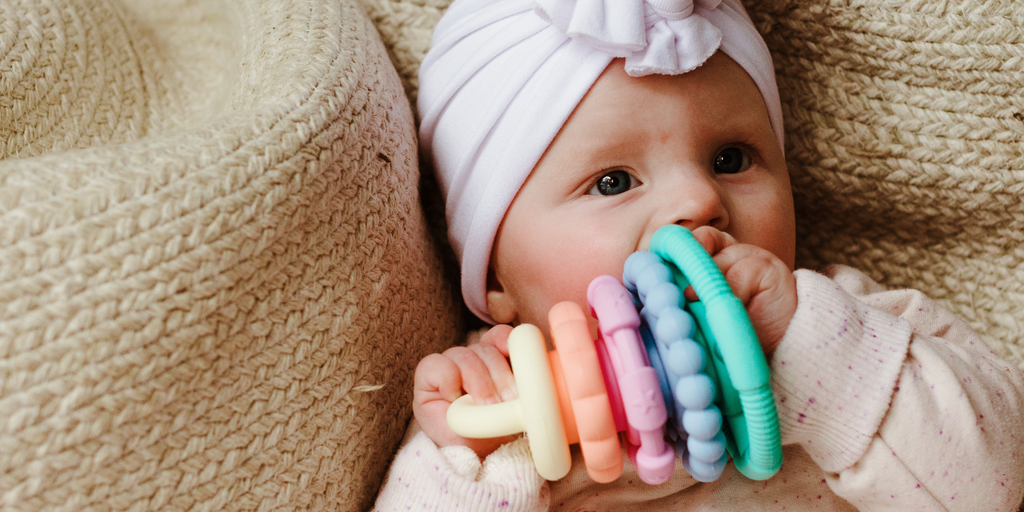 Baby Girl Chewing on Pastel Stacker.