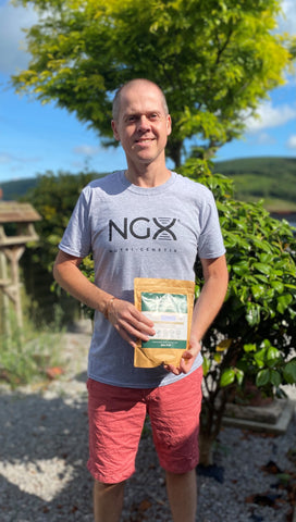 Man standing wearing an NGX top and holding a pouch of NGX BodyFuel