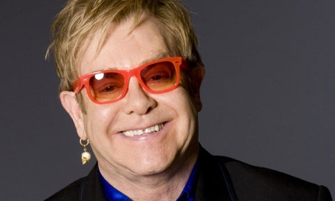Why does Elton John wear glasses?