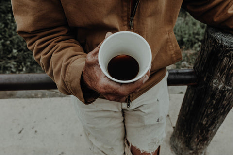 man holding cbd coffee in white cup