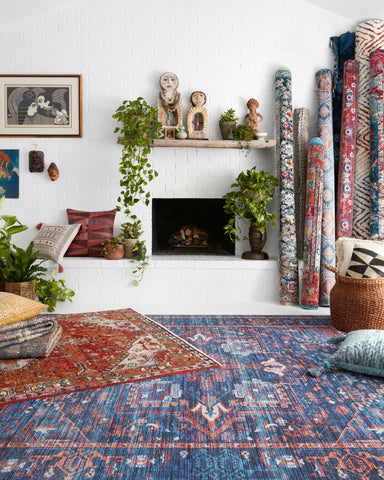 two rugs at an angle on the floor infront of a white brick modern fireplace.