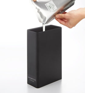 Black Shampoo Dispenser getting filled with shampoo on white background by Yamazaki Home. view 9