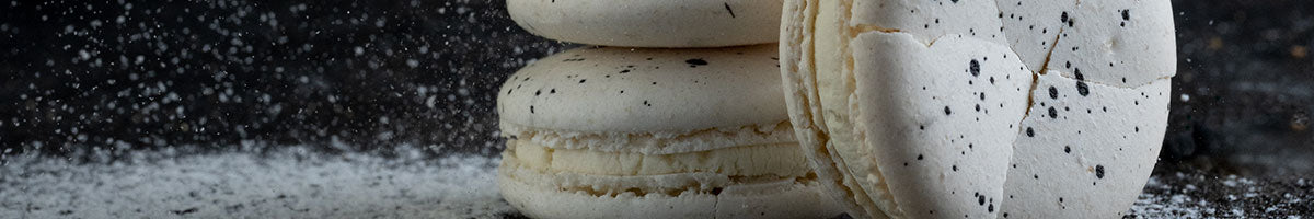 Powdered sugar being sprinkled on macaroon cookies.