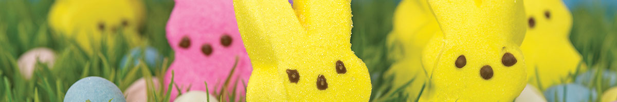 Lemon Marshmallow Bunnies of yellow and pink in the grass with eggs.