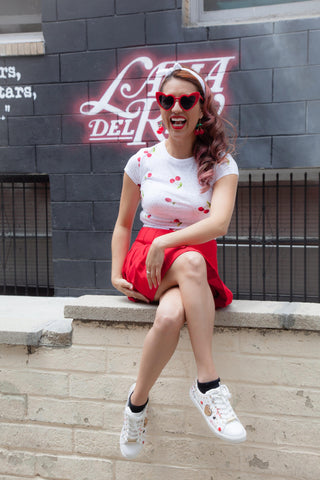Graffiti sneakers and red pleated skirt