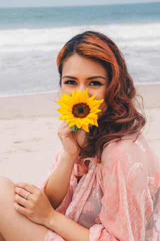 Girl with curly pink hair pink kimono and sunflower in mouth 